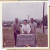 MAF0267a_photo-of-three-people-standing-behind-a-grave.jpg